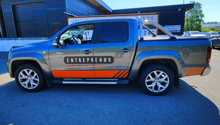 Entreprenør pickup designet af Gylling Skilte – flot grå og orange farvekombination, der giver et moderne og genkendeligt udtryk på farten. Eksempel på branding med fokus på kvalitet og synlighed i hverdagen.