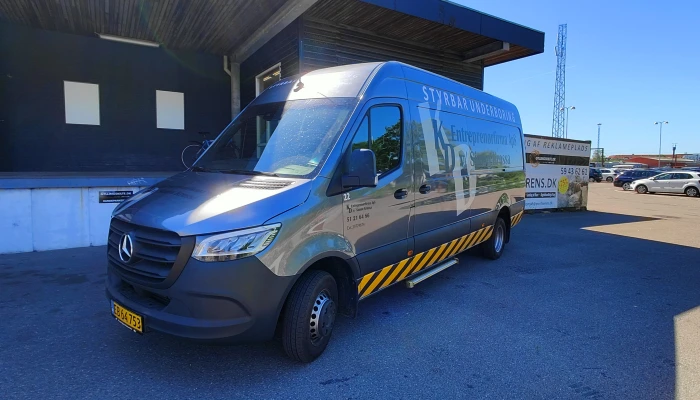 Entreprenør Mercedes Sprinter varevogn dekoreret af Gylling Skilte – stilrent design med logo, kontaktinfo og markante gule advarselsstriber, der kombinerer funktion og branding i ét professionelt udtryk.