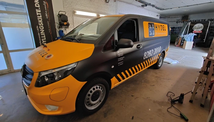 Professionel folieindpakning af Hydel servicebil udført af Gylling Skilte – elegant design i sort og gul med skarpe detaljer, der signalerer kvalitet og pålidelighed. En robust reklameløsning til håndværkere og erhverv.