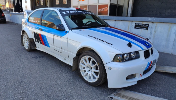 Racerbil for K.A. Motorsport med klassisk BMW-inspireret foliedesign udført af Gylling Skilte – et sporty og præcist look, der kombinerer fart, teknik og design i topklasse.