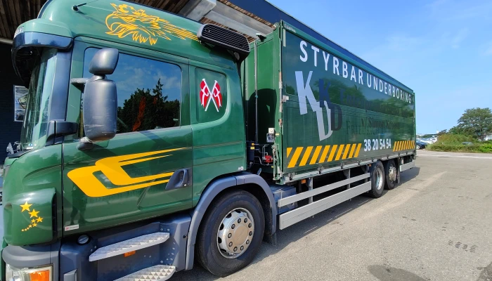 Professionel lastbilfolie for KLD Styrbar Underboring udført af Gylling Skilte – markant design i grønne og gule nuancer, der kombinerer synlighed, branding og kvalitet. En stærk profilering på vejene.