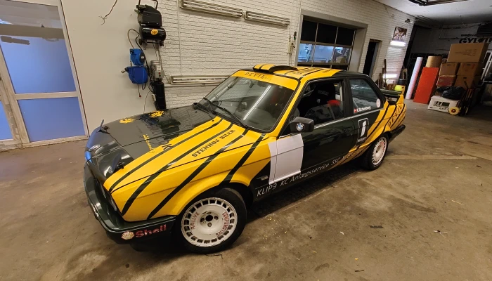 Klipso rallybil med specialdesignet folie fra Gylling Skilte – sporty look med gule og sorte racingstriber, der viser præcision, fart og kreativitet. En unik løsning skabt til motorsport med fokus på detaljer.