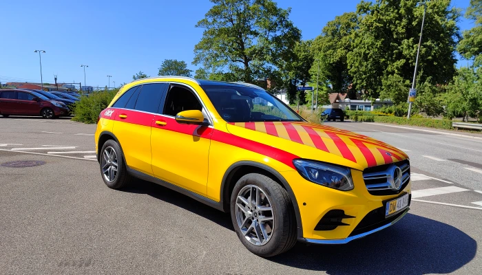 Mercedes SUV folieret i stærke gule og røde farver af Gylling Skilte – en sikkerheds- og brandbil med høj synlighed og perfekt udført foliearbejde.