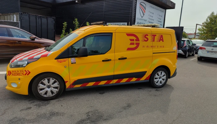 STA vejservicebil i skarpe gule og røde farver, designet af Gylling Skilte – høj synlighed og professionel skilteproduktion til trafiksikkerhed.