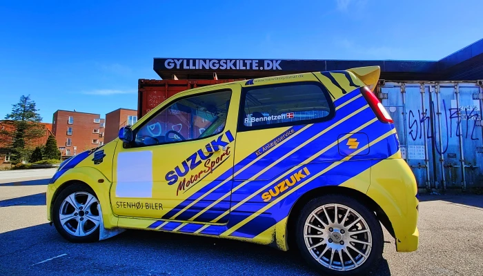 Suzuki Motorsports racerbilsdesign udført af Gylling Skilte – et iøjnefaldende foliearbejde, der kombinerer dynamiske linjer, stærke farver og professionelt håndværk. Perfekt eksempel på skræddersyet bildekoration, der styrker brandidentitet og synlighed.